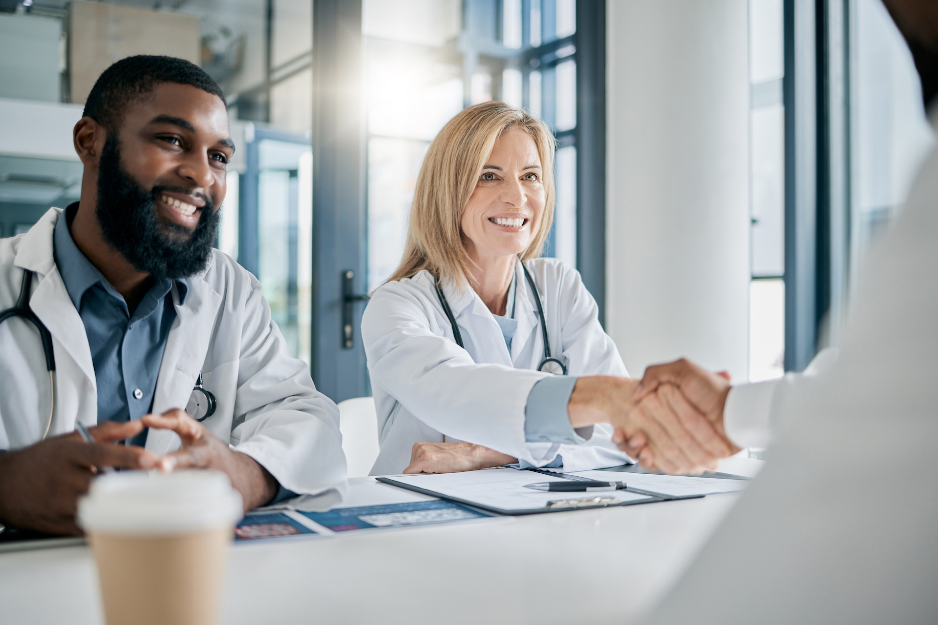 Handshake, partnership or happy doctors in a meeting after successful medical surgery or reaching h.
